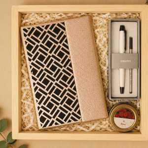 Elegant gift box with notebooks, pens, and a candle for The Rose Gold Elegance Gift Box.