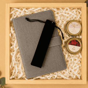 Elegant gift box with a gray notebook, candles, and greenery for The Marble Elegance Gift Box.