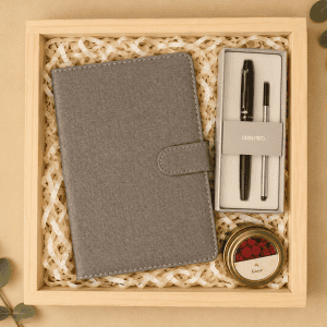 Gift box with a grey notebook, pens, and a candle for her.